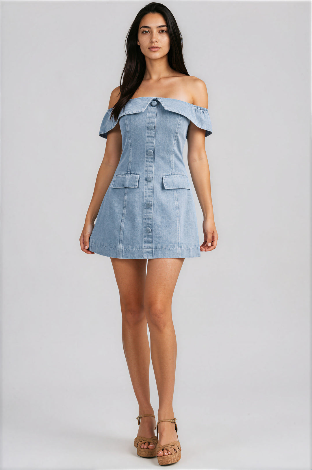 Woman wearing a denim off-shoulder dress on a gray background
