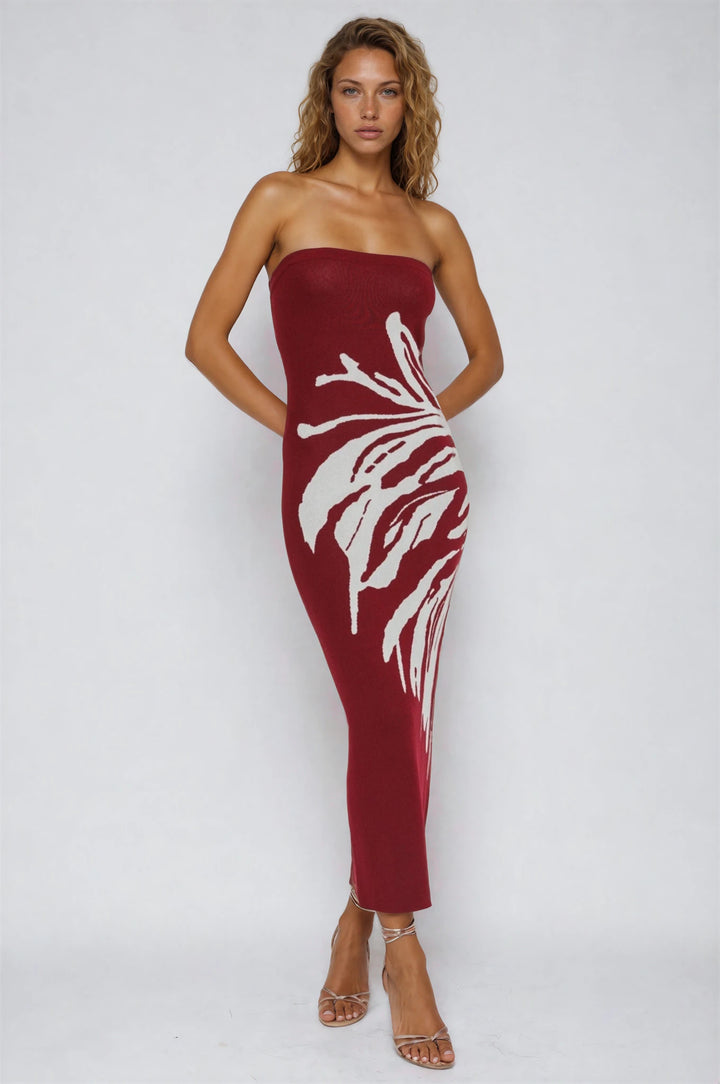 Woman wearing a strapless red dress with white floral patterns on a white background