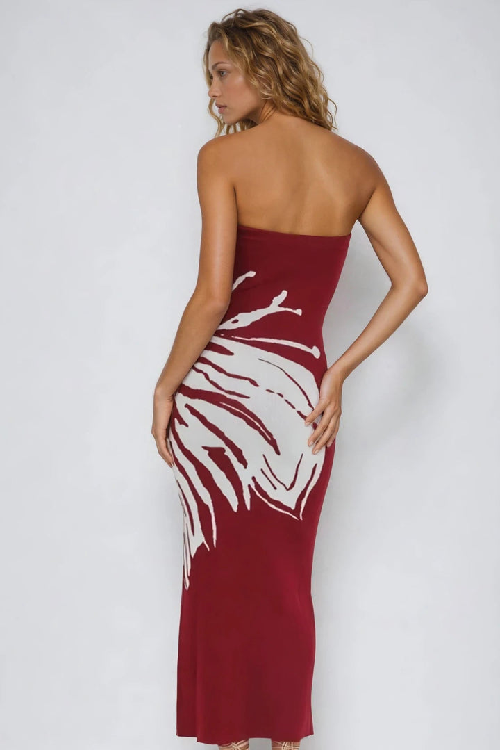 Woman wearing a red strapless dress with white abstract design on a white background