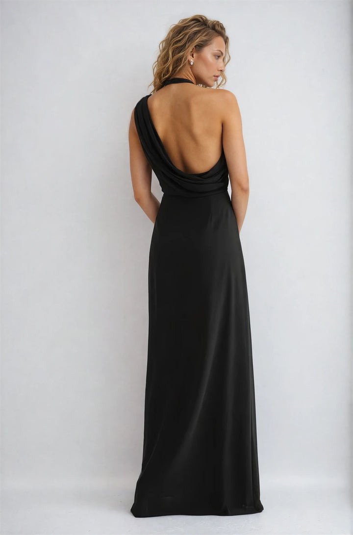 Woman wearing a black evening gown with an open back on a white background