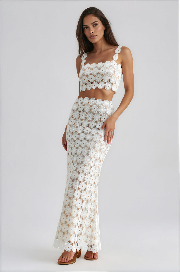 Woman wearing white crochet lace two-piece set with cropped tank top and high-waisted maxi skirt