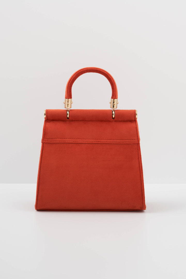 Red handbag with gold accents on a light gray background