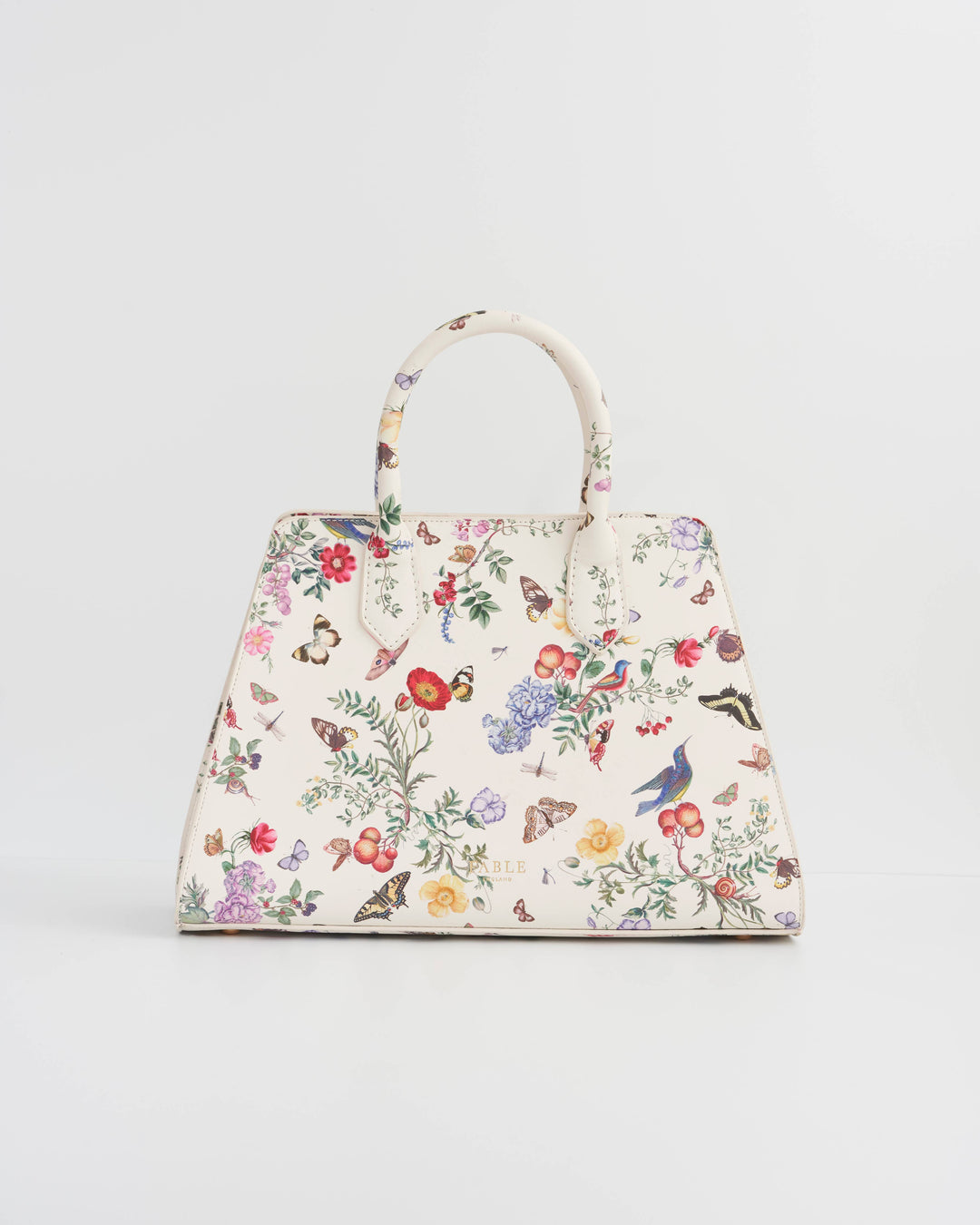 Floral and butterfly patterned handbag on a light gray background