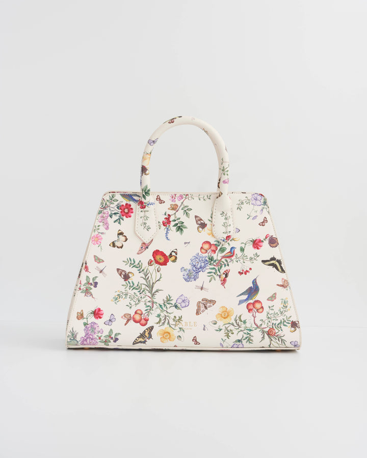 Floral and butterfly patterned handbag on a light gray background