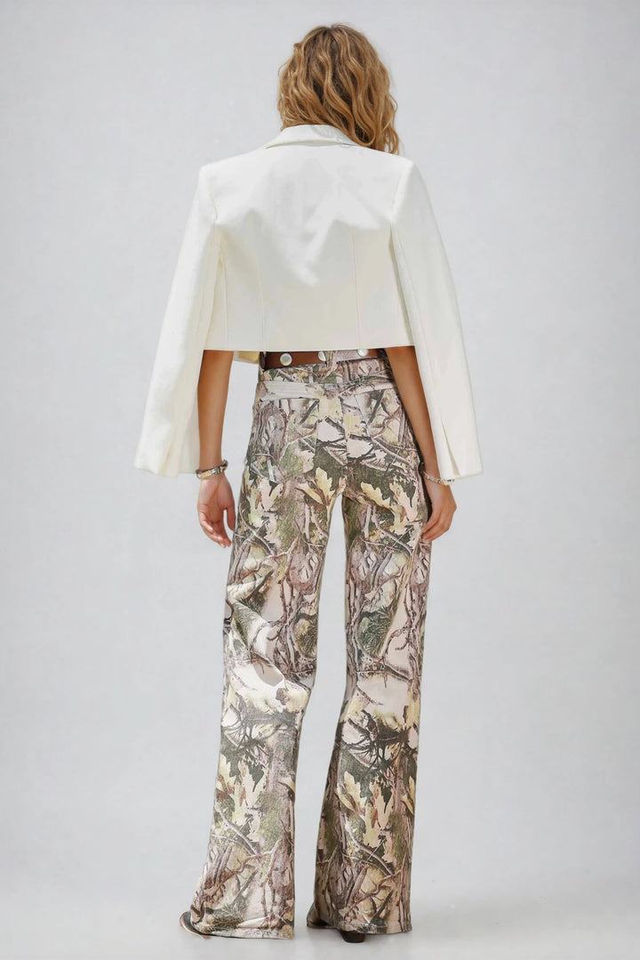 Person wearing a white jacket and camouflage pants on a plain background