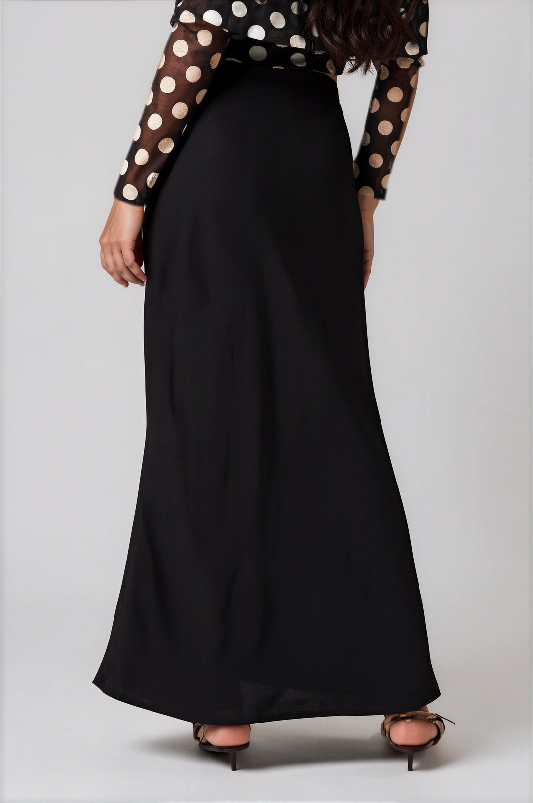 Back view black high waisted satin skirt on model