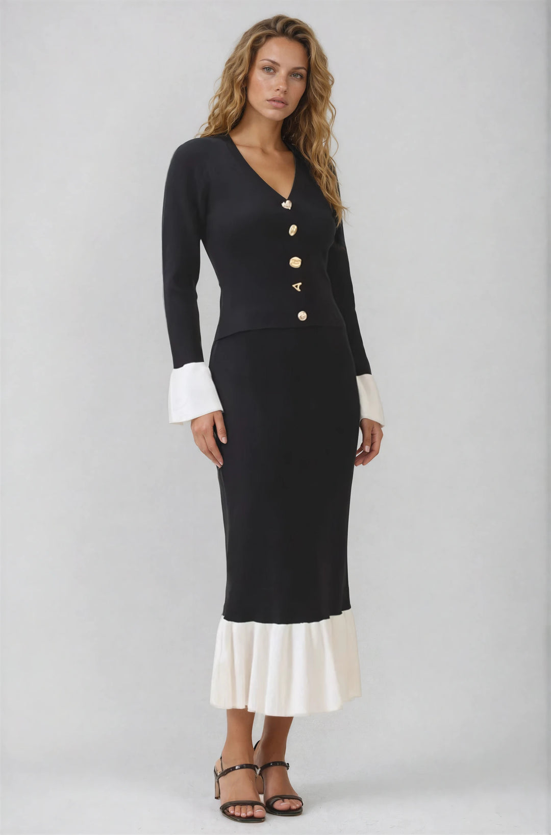 Side view black knit top and flared contrast hem skirt on model