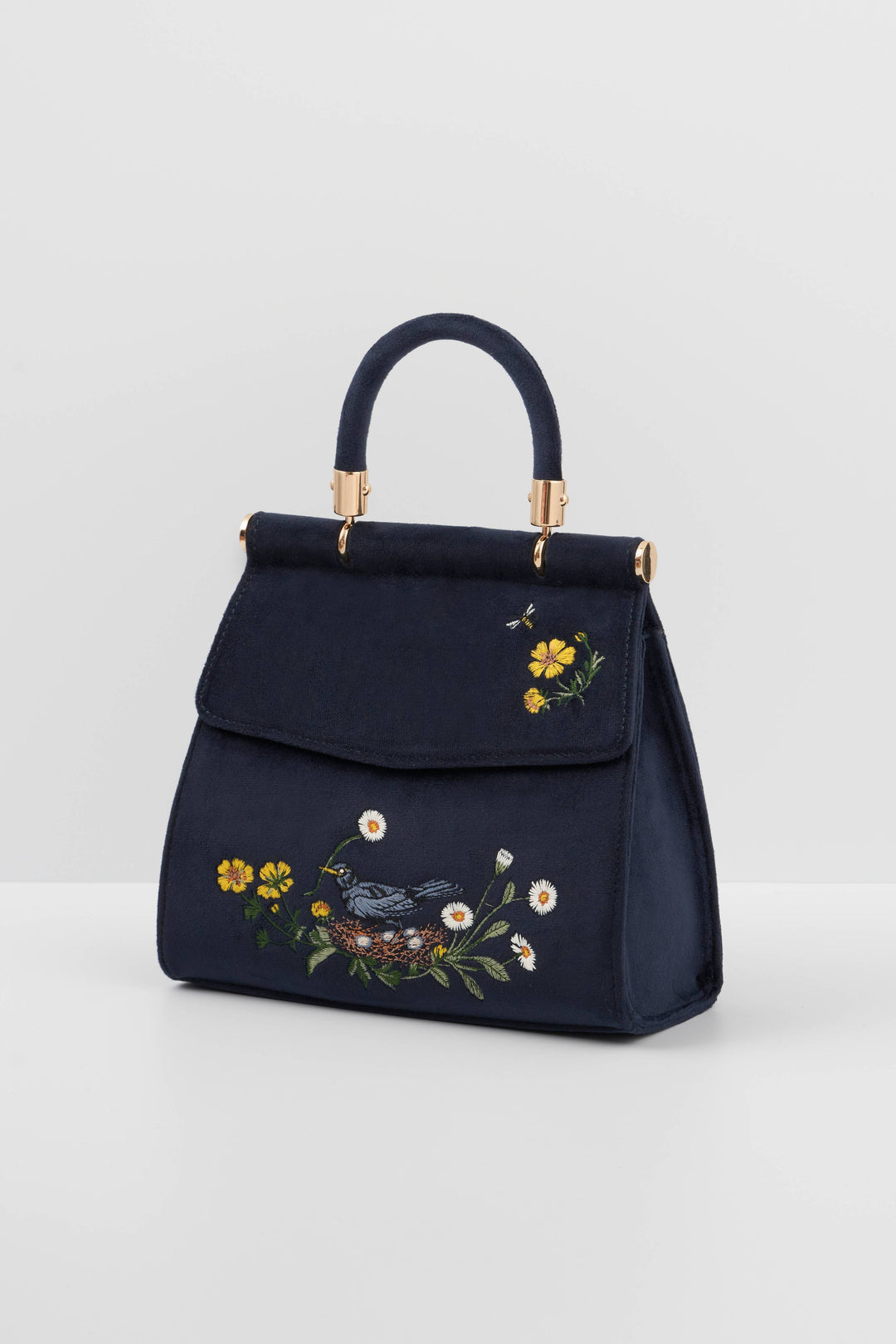 Navy blue handbag with floral embroidery on a light gray background