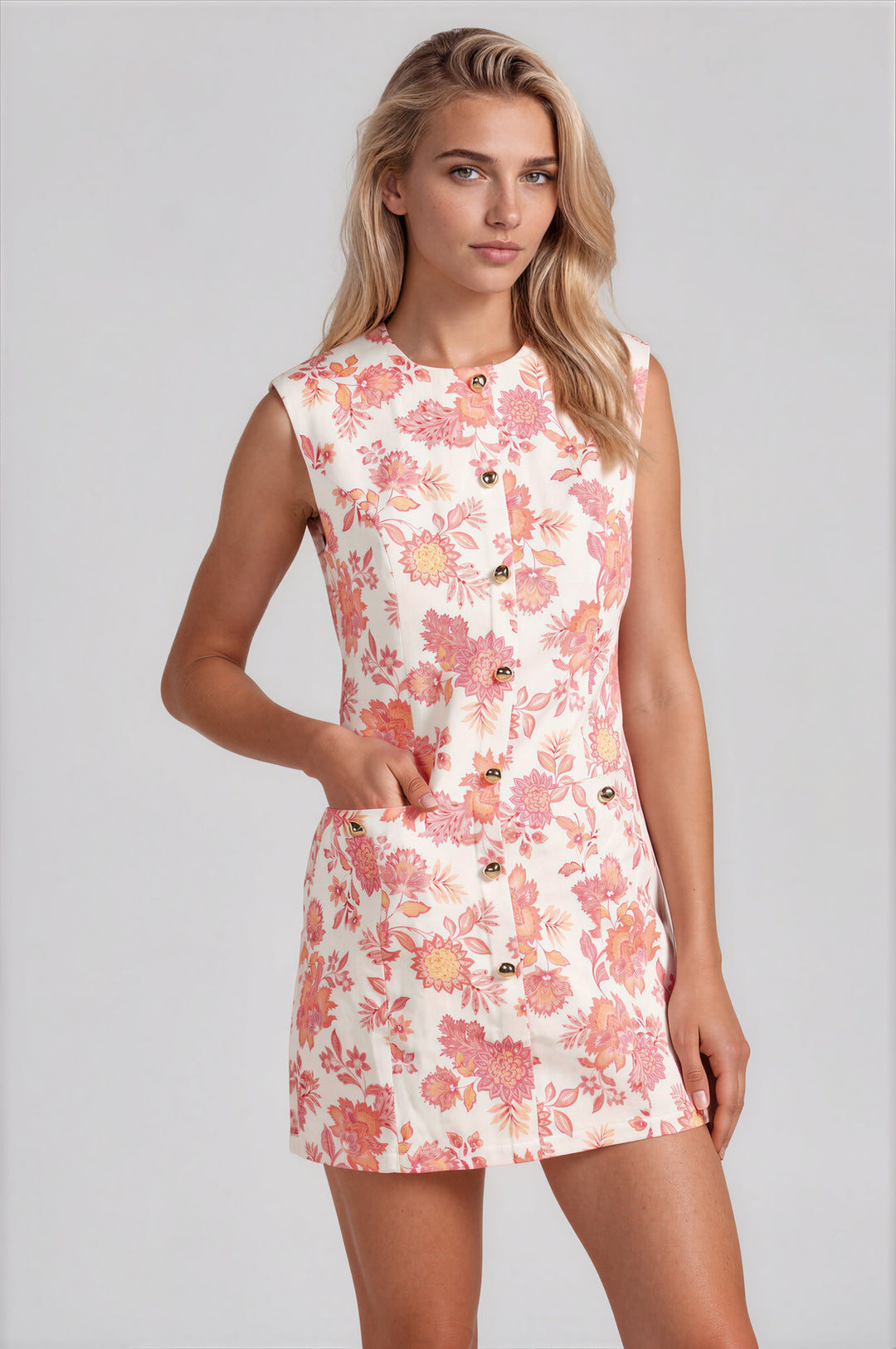 Woman wearing pink botanical floral print sleeveless sheath mini dress with gold button front