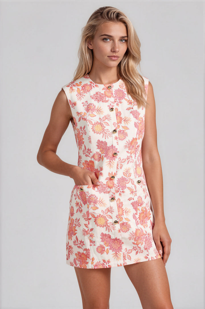 Woman wearing pink botanical floral print sleeveless sheath mini dress with gold button front