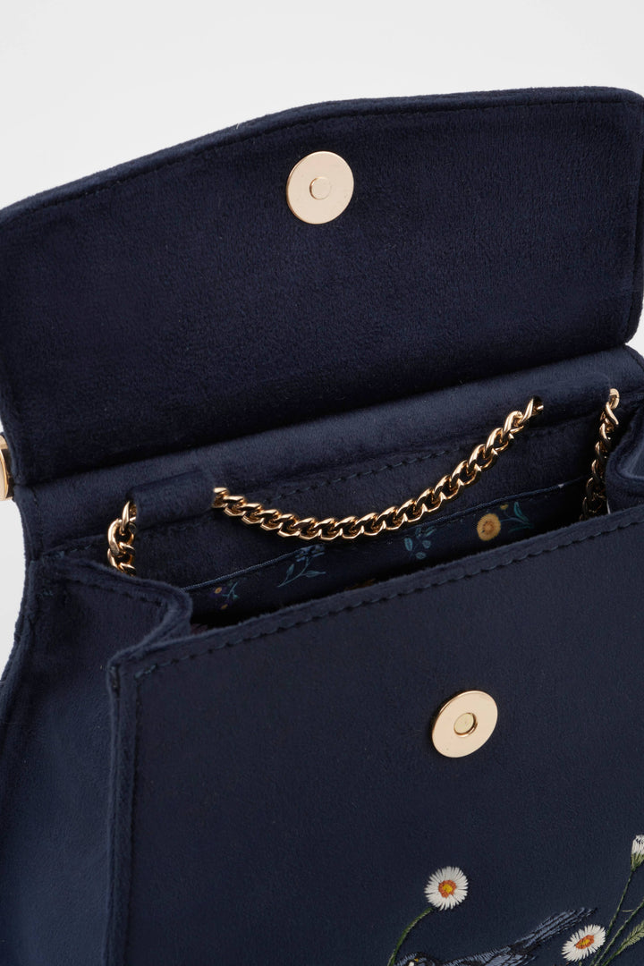 Navy blue handbag with gold chain and floral embroidery on a light gray background