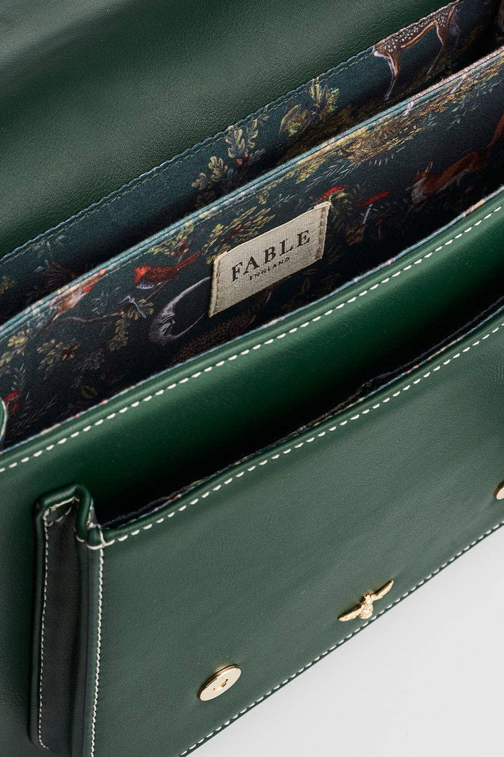 Green handbag with floral lining and 'Fable' label on a white background