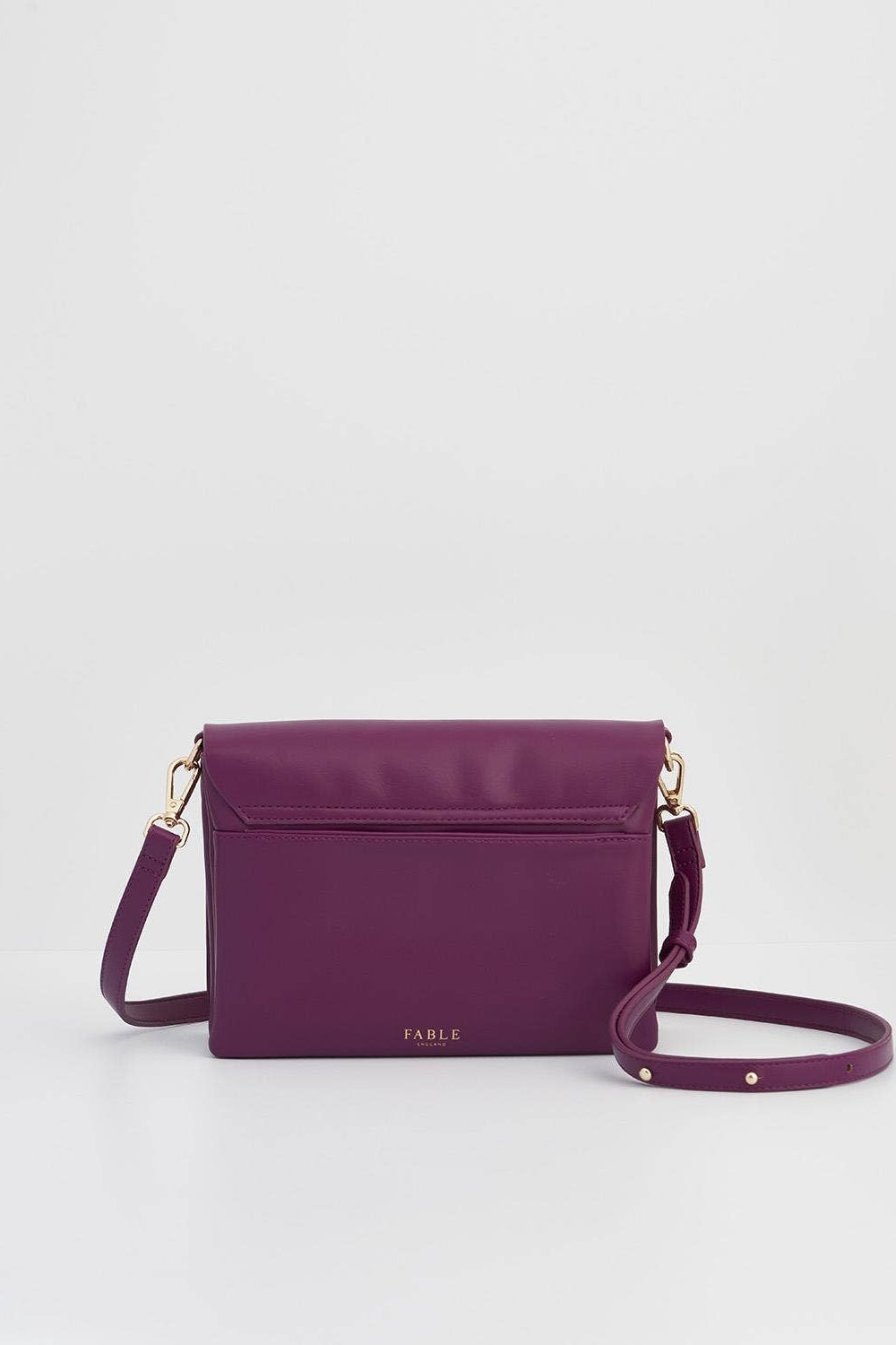 Purple handbag with gold accents on a light gray background