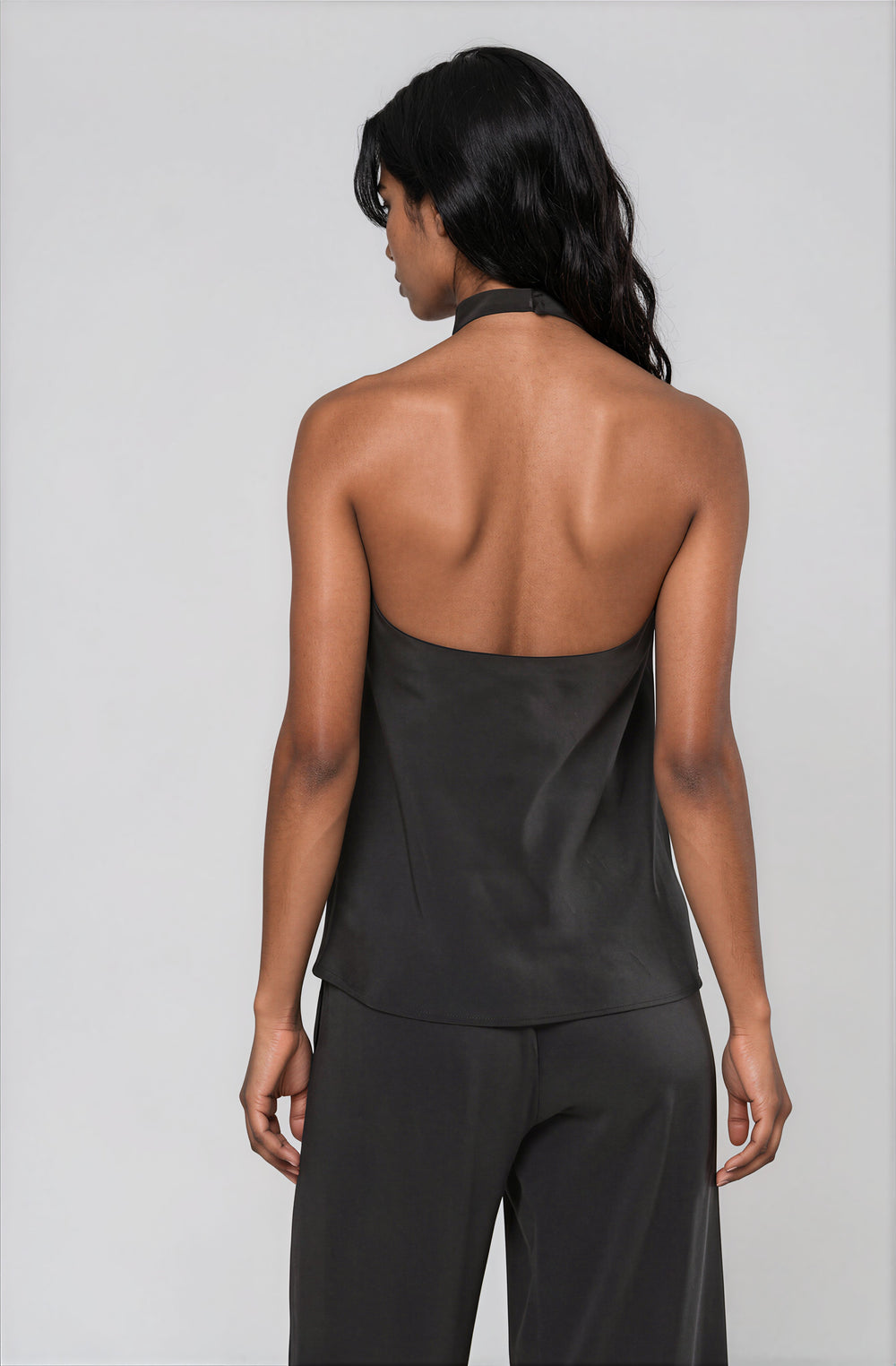 Back view black halter blouse with open back on model