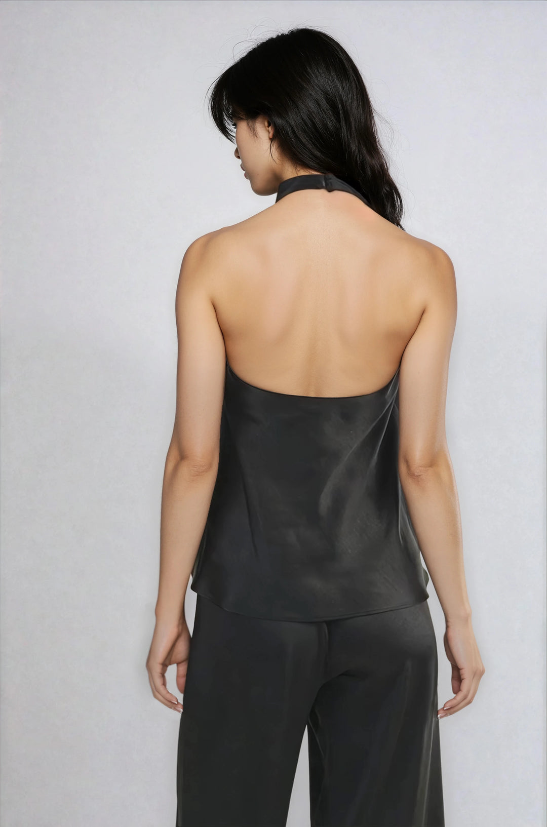 Back view black halter blouse with open back on model