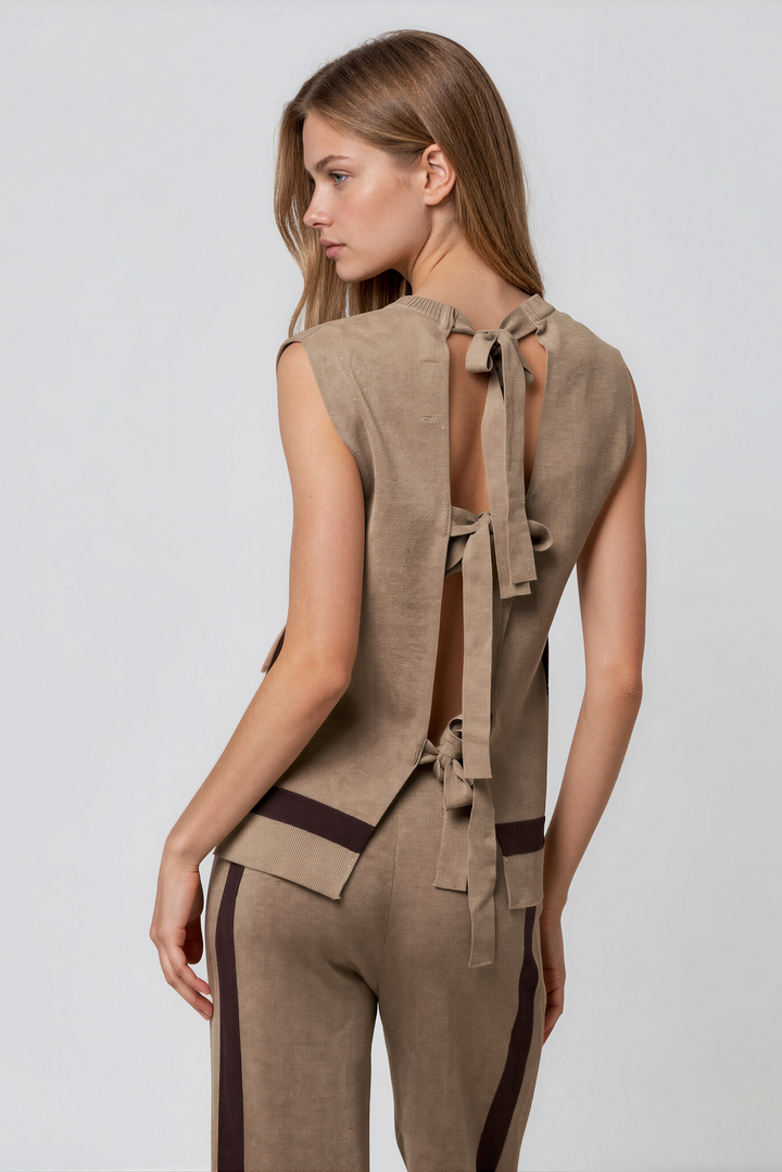 Back view of taupe knit sleeveless top with open self-tie bow back and matching wide-leg pants