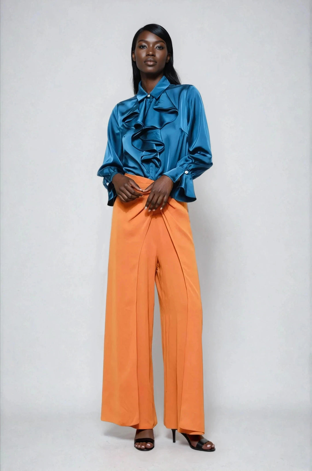 Blue ruffled blouse with cascading front detail on model