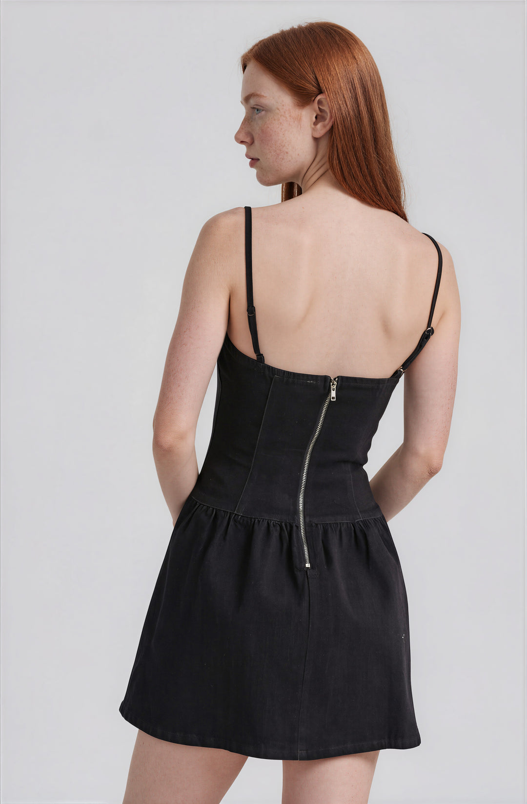 Back view dark denim mini dress with adjustable straps on model