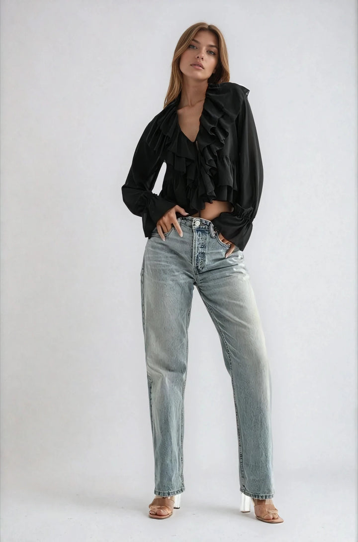 Black semi sheer blouse with cascading ruffles on model