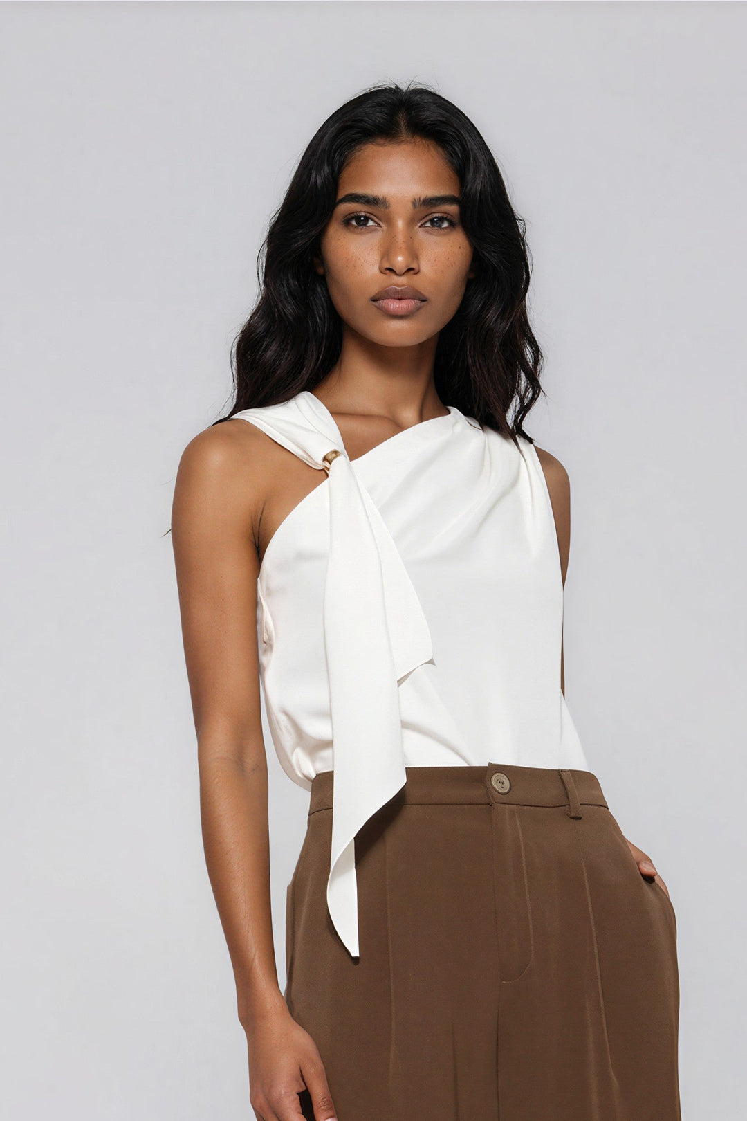 Ivory asymmetric sleeveless blouse with gold ring neckline on model